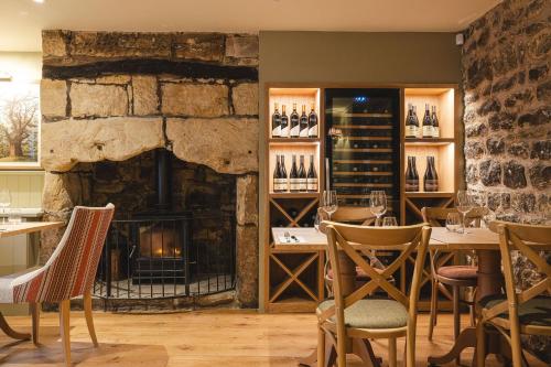 a restaurant with a fireplace and tables and chairs at Bertram's in Warkworth