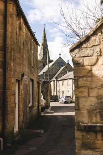 an alley in an old town with a church at Bertram's in Warkworth