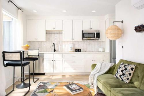 a living room with a green couch and a kitchen at Champagne Wishes in Atlanta
