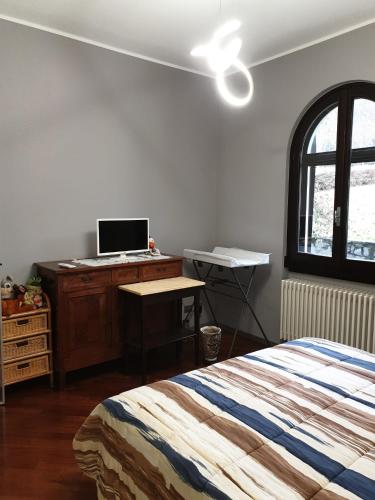 a bedroom with a bed and a desk with a laptop on it at Lake House in Vergiate
