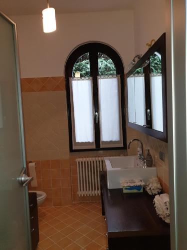 a bathroom with a tub and a sink and two windows at Lake House in Vergiate