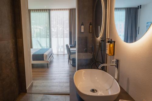 a bathroom with a sink and a bed and a mirror at LKL Lakeside Lodging in Paratico