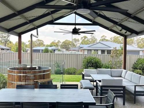 a patio with tables and couches and a ceiling fan at The Nagambie Stay in Nagambie