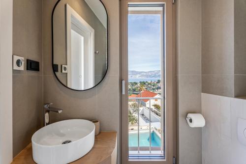 a bathroom with a white sink and a mirror at Lemon Tree Villa in Splitska