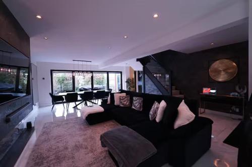 a living room with a black couch and a table at Modern tyne & wear house in North Tyneside