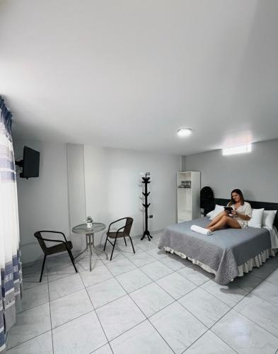 a woman sitting on a bed in a room at Sun Terrace Ilo Loft in Ilo