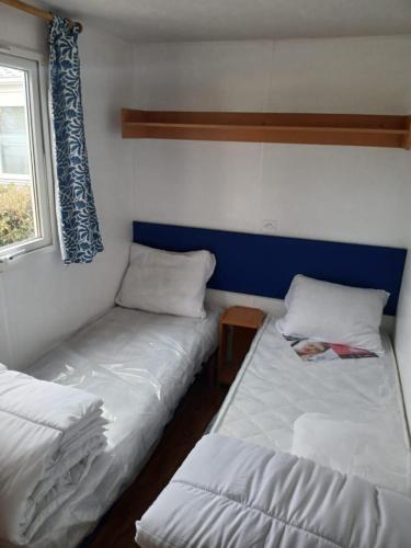 two beds in a small room with a window at Escapade aux Peupliers in Vironchaux