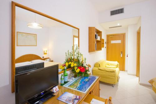 a living room with a tv and a couch at Ecoresort Le Sirene - Caroli Hotels in Gallipoli
