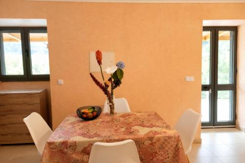 a dining room table with a vase of flowers on it at VViP Vila Madeira in São Vicente