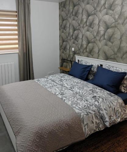 a bedroom with a large bed with blue pillows at Au pays des cigognes in Cambron-Casteau