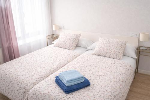 a bed with two pillows and a blue box on it at San Lorenzo House in Gijón