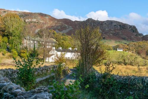 a house in a field with mountains in the background at 3 Bed in Little Langdale oc-gl102 in Little Langdale