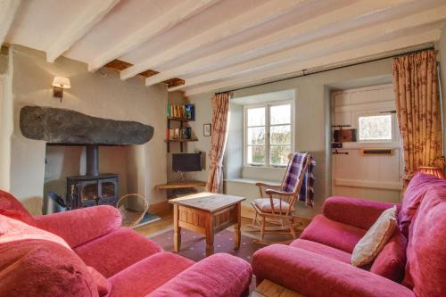 a living room with a red couch and a fireplace at 3 Bed in Little Langdale oc-gl102 in Little Langdale