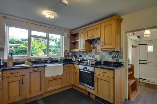 a kitchen with wooden cabinets and black counter tops at 3 Bed in Little Langdale oc-gl102 in Little Langdale