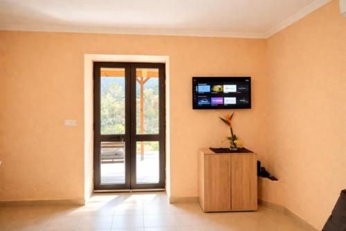a room with a door and a television on the wall at VViP Vila Madeira in São Vicente