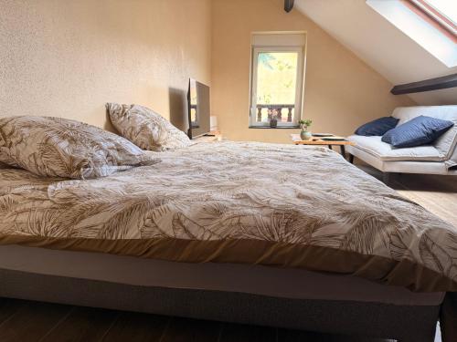a bedroom with a large bed and a couch at Appartement jacuzzi et spa étoile Mystérieuse in Belfort