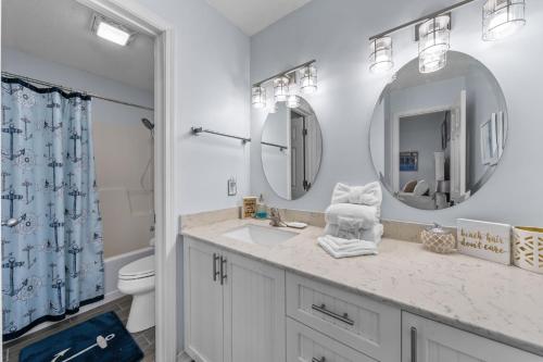 a bathroom with a sink and a toilet and a mirror at The Dunes 101 by Vacation Homes Collection in Fort Morgan