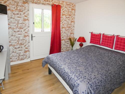 a bedroom with a bed and a red curtain at Les Bergeronnettes in Trénal