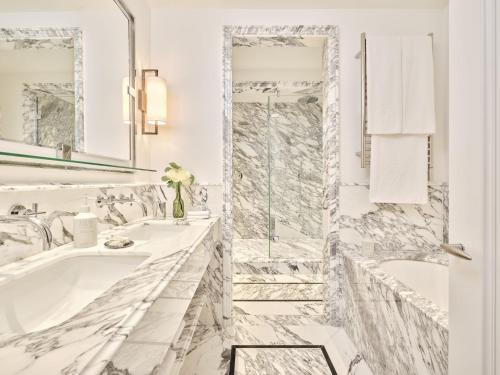 a bathroom with a tub and a shower with marble tiles at Brown's Hotel, a Rocco Forte Hotel in London