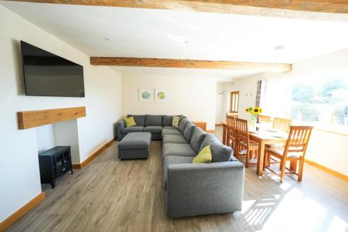 a living room with a couch and a table at Honeysuckle Cottage in Hele