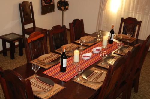 a dining room table with wine bottles and napkins at Grysbok Self Catering Accommodation in Oudtshoorn