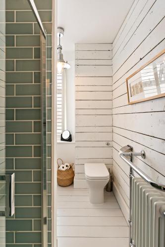 a bathroom with a toilet and a shower at Waterside cottage - log burner - 10 mins to Falmouth in Flushing