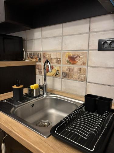 a kitchen counter with a sink and a kitchen counter top with a stove at Kromatic 5 Boutique Studios - Old town Center in Braşov