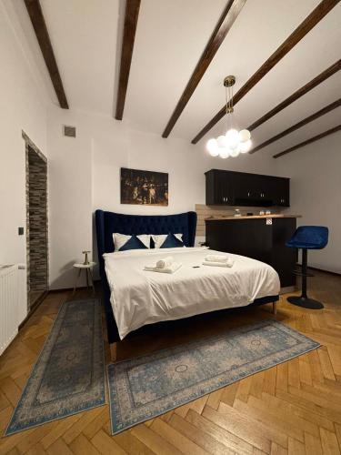 a bedroom with a bed and a blue chair at Kromatic 5 Boutique Studios - Old town Center in Braşov