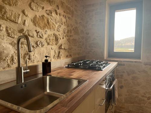 a kitchen with a sink and a stove at Vineyard Farmhouse in Massignano in Massignano