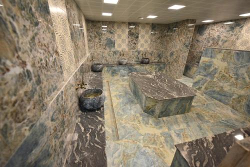 a large stone bathroom with a large stone table at Anemon Grand Şanlıurfa in Göktepe