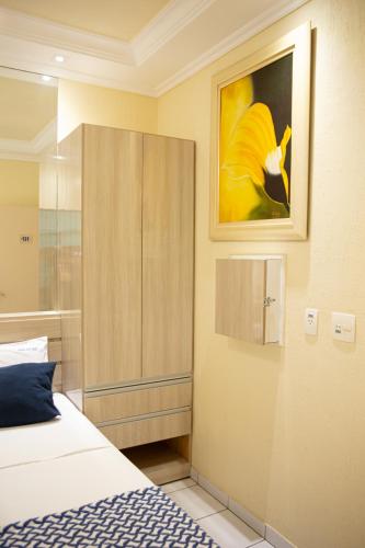 a bedroom with a bed and a painting on the wall at Polar Rio Hotel in São Paulo