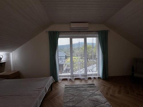 a bedroom with a bed and a large window at Bilia Tustani in Urych