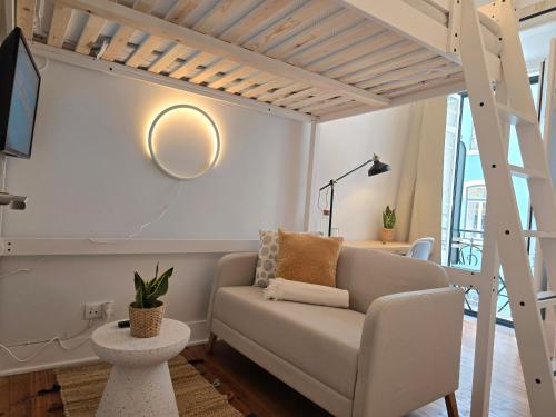 a living room with a couch and a tv at Estrela Charming Rooms by HOST-POINT in Lisbon