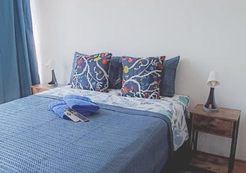 a bed with a remote control on top of it at Departamentos Home Bulnes in Santiago