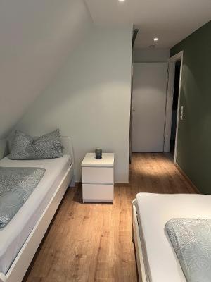 a bedroom with two beds and a night stand at CasaCremer 3 in Übach-Palenberg