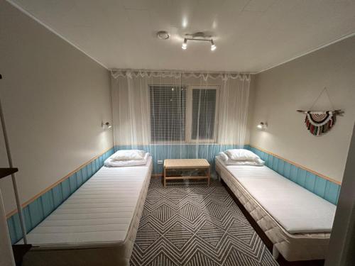 pokój z dwoma łóżkami i stołem w obiekcie Metsa Hostel w mieście Võsu