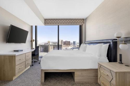 a bedroom with a large bed and a large window at Suites at Elara Las Vegas Center Strip-No Resort Fees in Las Vegas