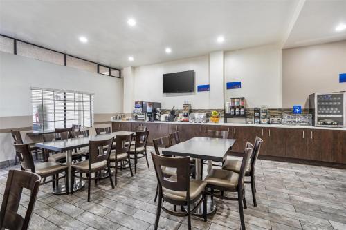 a restaurant with tables and chairs and a counter at Best Western Airpark Hotel - LAX Airport LA Stadium in Inglewood