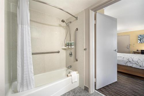 a bathroom with a tub and a shower with a bed at Best Western Airpark Hotel - LAX Airport LA Stadium in Inglewood