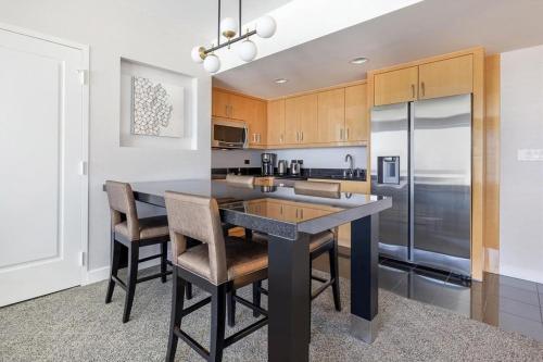 a kitchen with a table and chairs and a refrigerator at Suites at Elara Las Vegas Center Strip-No Resort Fees in Las Vegas