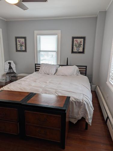 a bedroom with a large bed with a wooden dresser at Nantasket Beach - early birds - booking summer 2027 in Hull