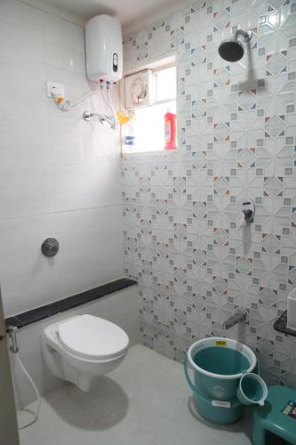 a bathroom with a white toilet and a window at 2bhk penthouse with open tarace in Vadodara