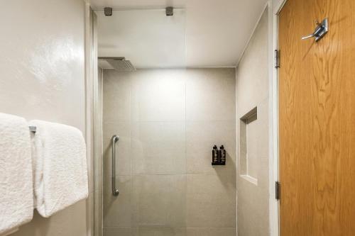 a bathroom with a shower with a glass door at Fiesta Inn Express Hermosillo in Hermosillo
