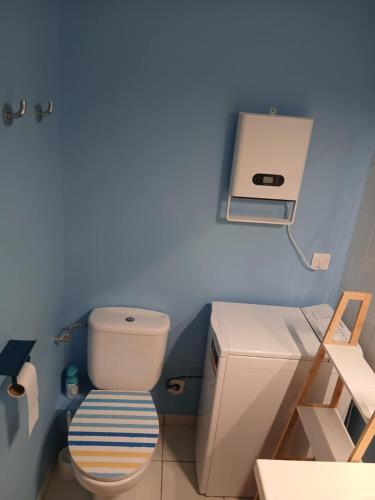 a blue bathroom with a toilet and a sink at Appartement Carcans Maubuisson in Carcans