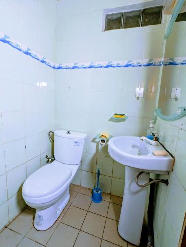a bathroom with a toilet and a sink at Appartement Meublé 3 Chambres in Douala