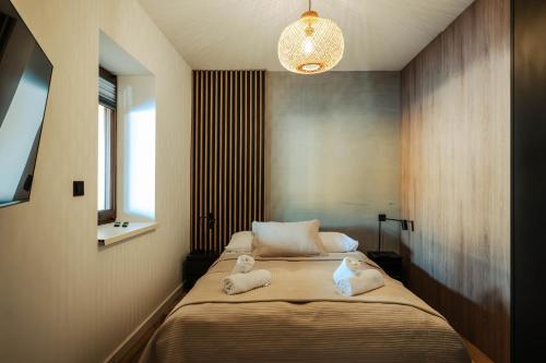 a bedroom with a bed with towels on it at Apartamenty Fuleda nad jeziorem Dobskim Mazury Holiday in Fuleda