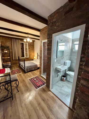 a bathroom with a bed and a sink in a room at InTown Guesthouse Shkoder in Shkodër