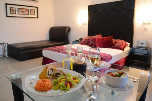 una habitación con una mesa con un plato de comida y una cama en Hotel Calima Real, en Cali