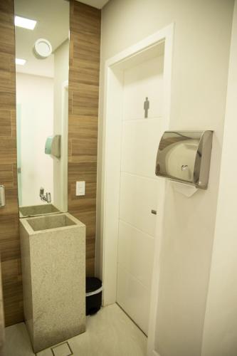 a bathroom with a sink and a paper towel dispenser at Polar Rio Hotel in São Paulo