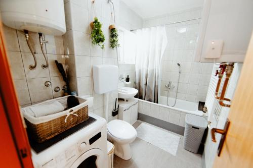 a white bathroom with a toilet and a sink at Apartman Deja vu in Livno